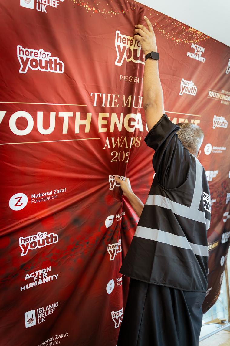 A crew member adjusting the awards backdrop before the ceremony.